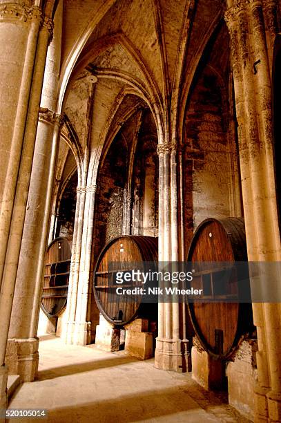 Wine vats stand beside pillars in the church of the former 13C Cistercian Abbey of Valmagne near Pezenas, Herault, in Languedoc Roussillon, France