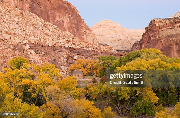 capitol reef national park, utah. usa. historic fruita schoolhouse in fremont river canyon at dusk in autumn. capitol dome in distance. - fruita colorado stock pictures, royalty-free photos & images