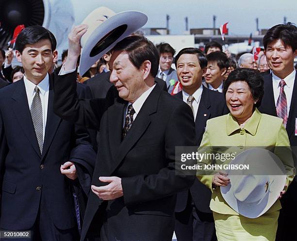 Chinese Premier Zhu Rongji tries on his cowboy hat while his wife Lao An looks on at the welcoming ceremony at the Calgary International Airport 17...