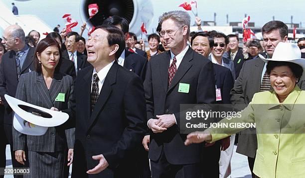 Chinese Premier Zhu Rongji laughs after trying on his new cowboy hat with his wife Lao An during the welcoming ceremony at the Calgary International...