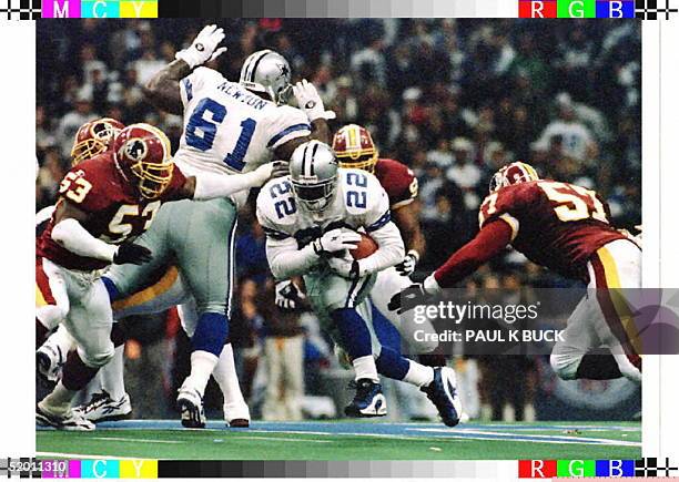 Emmitt Smith of the Dallas Cowboys breaks through the Washington Redskins line for short yardage 28 November at Texas Stadium in Irving, Texas. Smith...