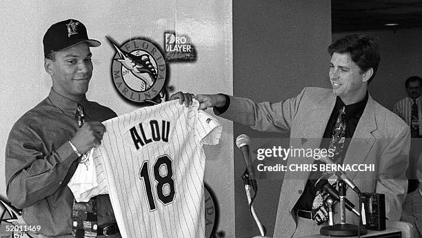 Free agent outfielder Moises Alou smiles as he shows off his jersey 12 December during a press conference at Pro Player Stadium in Miami, Florida,...