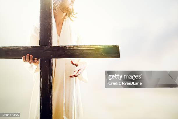 jesus christ holding cross - cross stockfoto's en -beelden