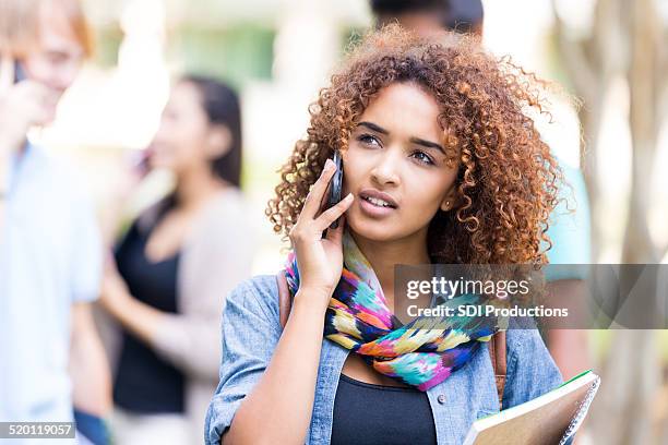 college student having conversation on cell phone outdoors - beautiful ethiopian girls stockfoto's en -beelden