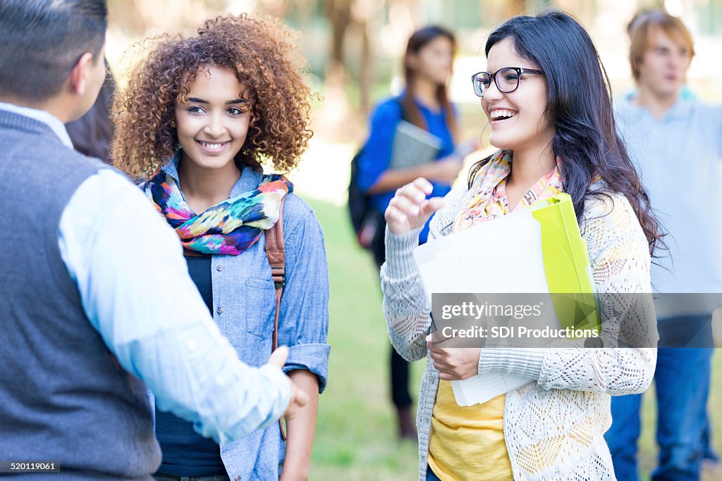 Stylish college students talking together outdoors on campus