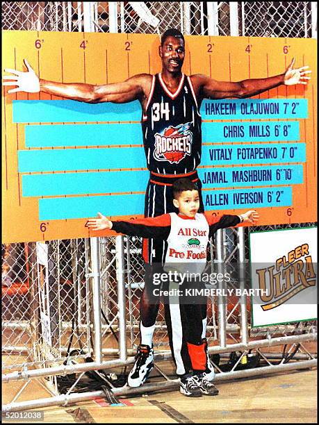 Dionte Neves of Mentor, OH, measures his arm span against the likeness of NBA player Hakeem Olajuwon, of the Houston Rockets, 06 February at the...