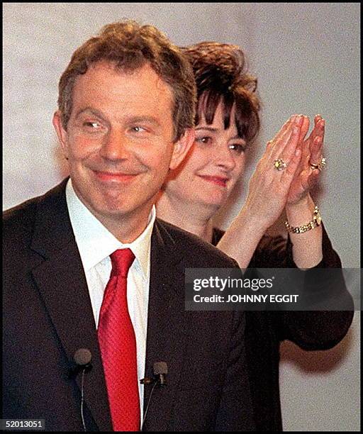 With his wife Cherie clapping behind him Labour Party leader and new British Prime Minister Tony Blair smiles at his party workers and supporters...