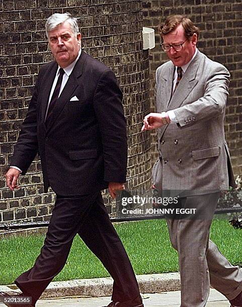 Ulster Unionist Party leader David Trimble checks the time as he and John Taylor arrive at No 10 Downing Street for a meeting with British Prime...