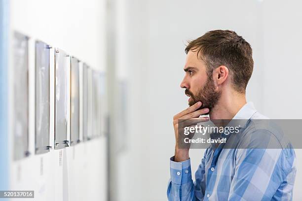 hipster man visiting an art gallery - looking at art stock pictures, royalty-free photos & images