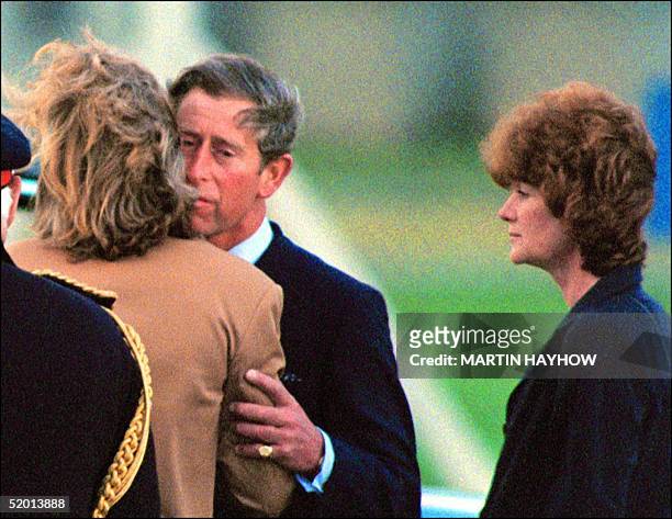 Britain's Prince Charles kisses Lady Sarah McCorquiodale while her sister Lady Jane Fellows looks on at RAF Northolt Airport near London 31 AUG....