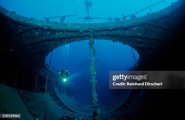 scuba diver exploring a shipwreck, papua new guinea, coral sea. - archaeology stock pictures, royalty-free photos & images