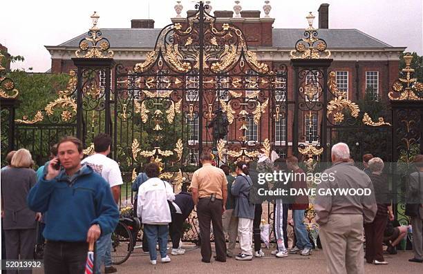 Crowds stand in silence outside the home of the Princess of Wales Kensington Palace after it was announced that she had died early today after a...