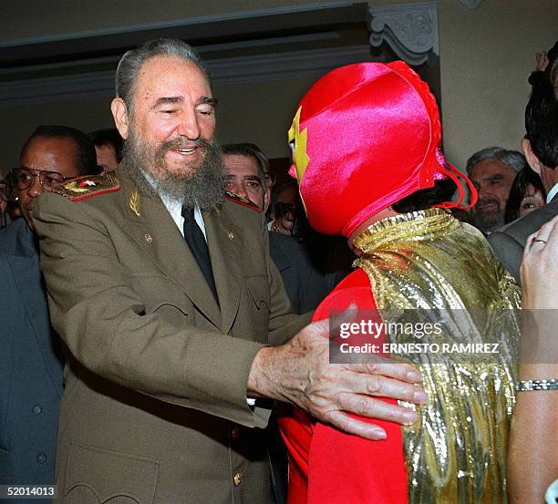 Cuban President Fidel Castro shown in file photo dated 02 December 1994 greeting Mexican wrestler Superbarrio Gomez, famous for defending the poor,...