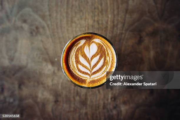 cortado served in a glass with foam latte art, seen directly from above - froth art stock pictures, royalty-free photos & images