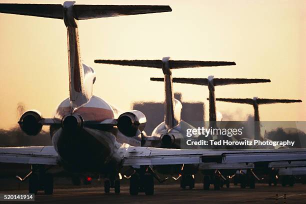 airline jets lined up on runway - airport waiting stock pictures, royalty-free photos & images