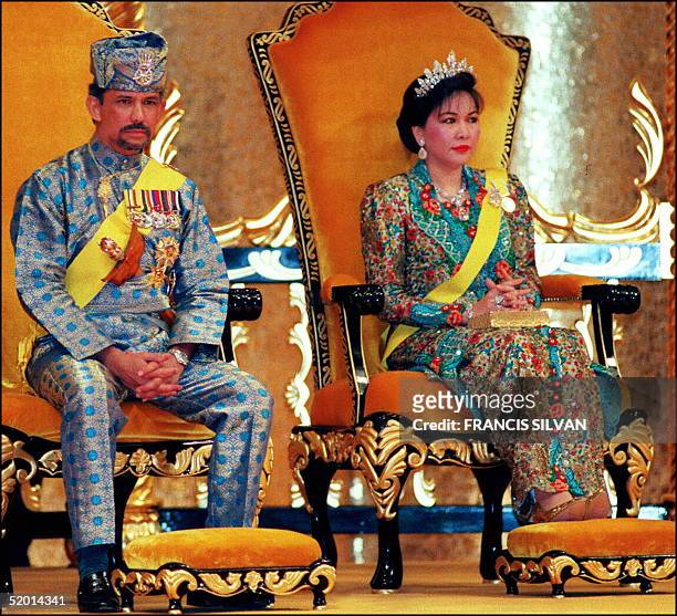 The Sultan of Brunei, Hassanal Bolkiah and Queen Hajah Mariam shown in this file picture dated 15 July 1996 as they sit on the throne during an...