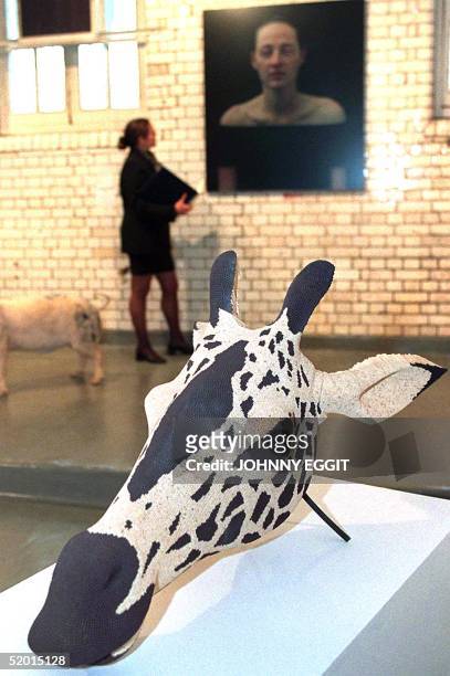 Visitor takes a look 14 April at "Giraffe Matchead 2" made from safety matches on a metal frame, executed in 1997 by David Mach and expected to sell...