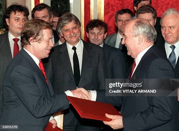 Former dissident playwright and Czechoslovakian President Vaclav Havel and Soviet President Mikhail Gorbachev shake hands as they exchange documents...