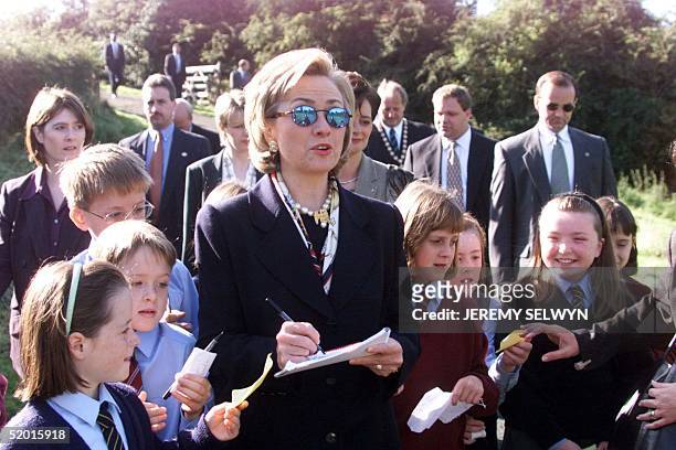First Lady Hillary Clinton signs autographs for children during a visit to Lagan Meadows, Belfast, 03 September shortly before the arrival of her...