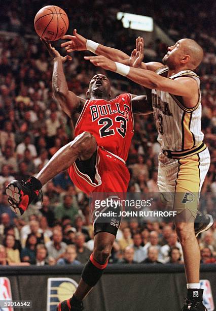 Michael Jordan of the Chicago Bulls is fouled by Mark Jackson of the Indiana Pacers 25 May during the second half of game four of their NBA Eastern...