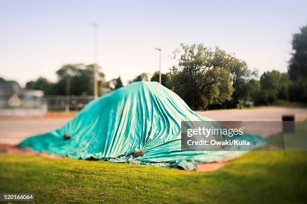 green tarp over pile in corner of parking lot - tarpaulin 個照片及圖片檔