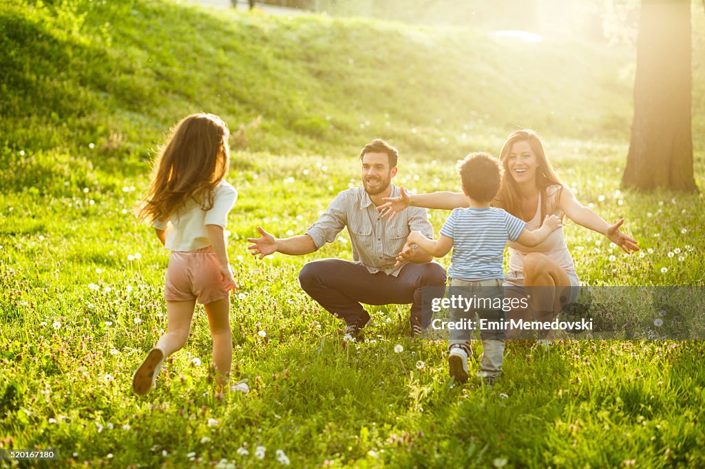 Two kids running to their parents in parks