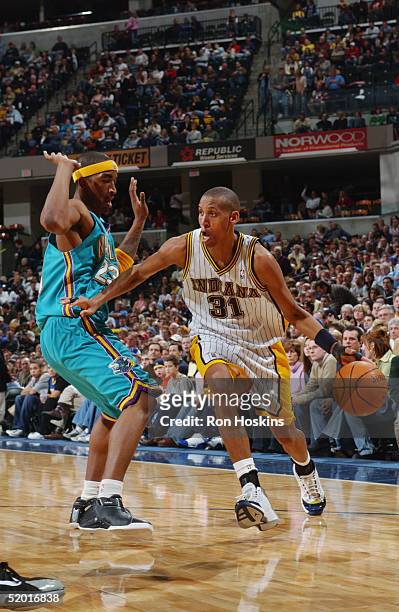 Reggie Miller of the Indiana Pacers drives to the basket against J.R. Smith of the New Orleans Hornets December 27, 2004 at Conseco Fieldhouse in...