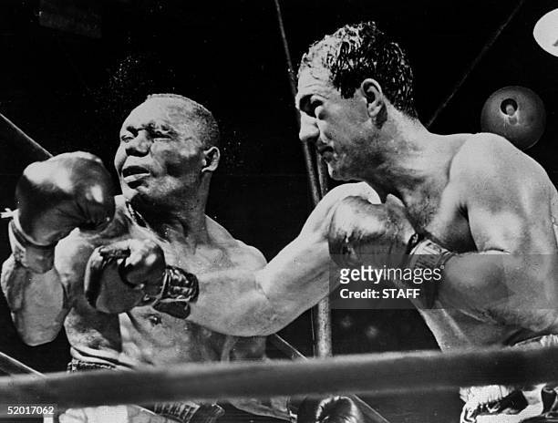 American boxing champion Rocky Marciano throws a right swing to his country fellow heavyweight boxing world champion Joe Walcott, September 1952 in...