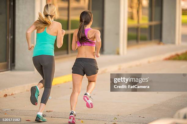 girlfriends running together - spandex stockfoto's en -beelden