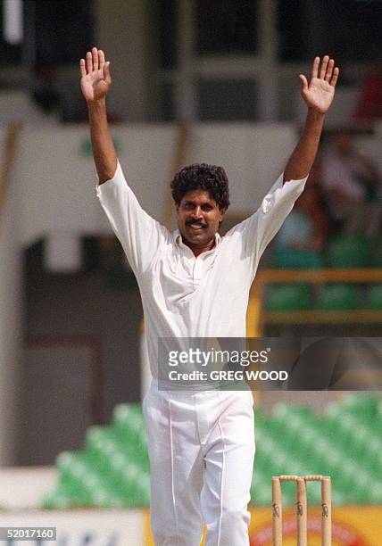 Indian bowler Kapil Dev raises his arms after taking his 400th test wicket during the fifth test against Australia in Perth 03 February 1992.