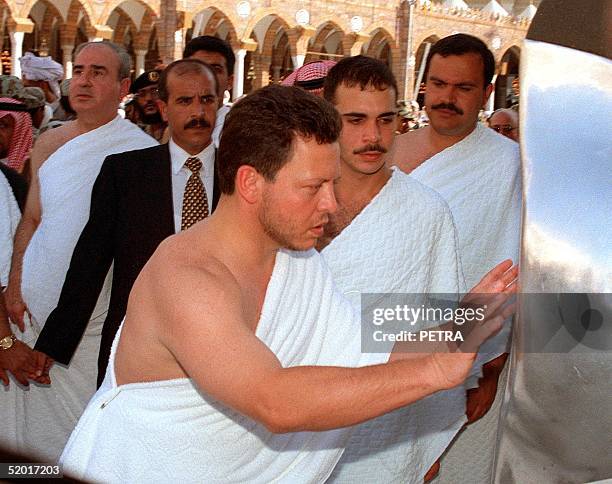 King Abdallah II of Jordan touches the holy stone as he performs the Omra pilgrimage at Mecca 06 April 1999. Jordanian officials hailed the king's...