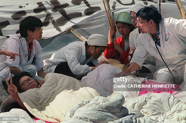 Paramedics take care of ailing student student hunger strikers from Beijing University 17 May 1989 at Tiananmen Square as students enter the 5the day...