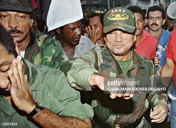 Panamian leader General Manuel Antonio Noriega fakes a punch to a supporter 02 May 1989 at the laying of the foundation of a group home in the...