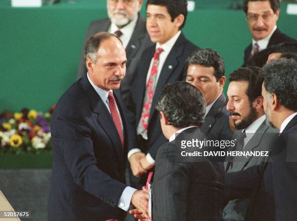 Salvadoran President Alfredo Cristiani shakes hands with Salvadoran guerrilla leaders : Schafik Handal, Joaquin Villalobos, Salvador Sanchez and...