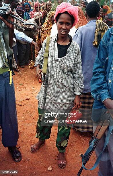Somali armed woman looks at photographer in a crowd jubilating over the defeat of forces loyal to Somali warlord Hussein Aidid in the town of Baidoa...