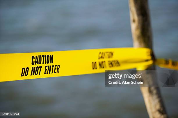 yellow "caution" tape - señal de prohibido la entrada fotografías e imágenes de stock
