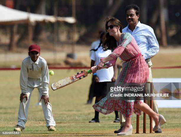 Catherine, Duchess of Cambridge is watched by former Indian cricketer Dilip Vengsarkar as she and an unseen Prince William, Duke of Cambridge play a...