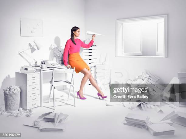 woman in a white room with paper planes. - killing time stock pictures, royalty-free photos & images