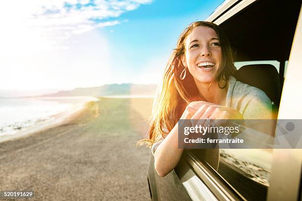 young woman on road trip looking out the car window - bonneville salt flats stock pictures, royalty-free photos & images