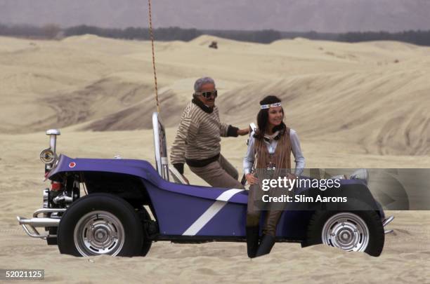 French-born American industrial designer Raymond Loewy with his second wife Viola and their dune buggy in the desert near Palm Springs, California,...