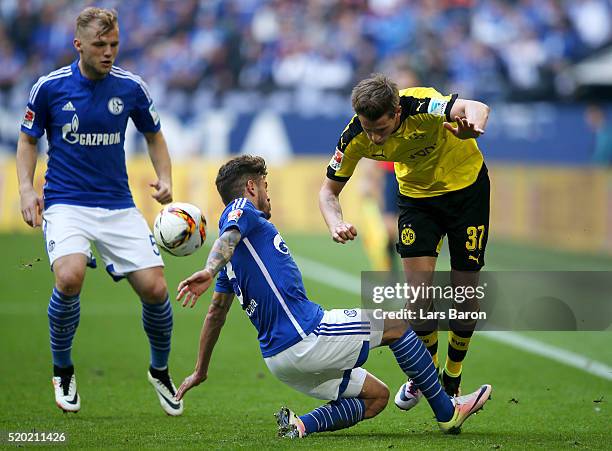 Junior Caicara and Johannes Geis of FC Schalke 04 battle for the ball with Erik Durm of Borussia Dortmund during the Bundesliga match between FC...