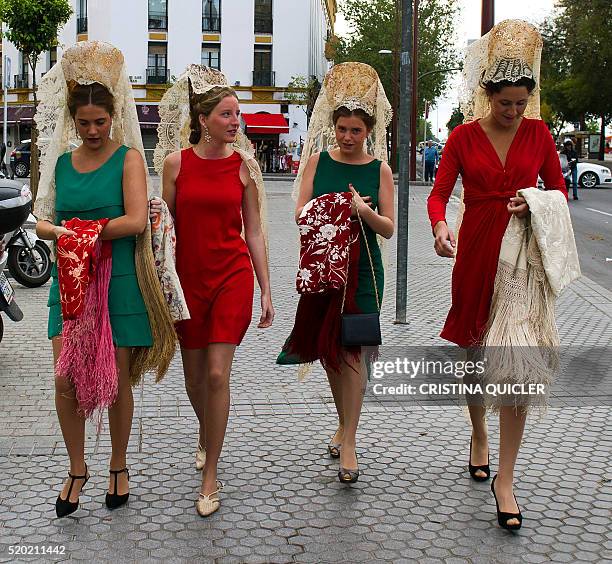 Women wearing the traditional headwear and "mantilla" walk to attend the XXXI "Enganches" exhibitiont at the Real Maestranza bullring in Sevilla on...