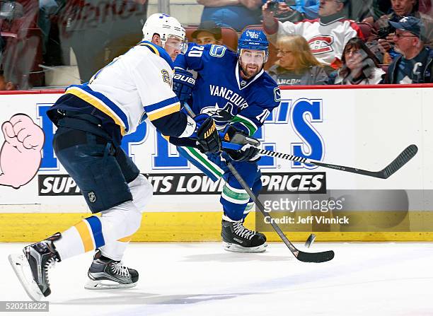 Patrik Berglund of the St. Louis Blues and Chris Higgins of the Vancouver Canucks watch a loose puck during their NHL game at Rogers Arena March 19,...