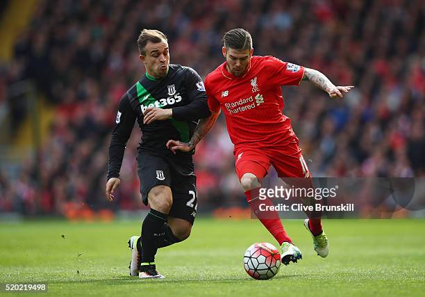 Alberto Moreno of Liverpool is challenged by Xherdan Shaqiri of Stoke City during the Barclays Premier League match between Liverpool and Stoke City...