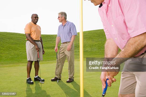 golfers talking on golf course - golf short iron stock pictures, royalty-free photos & images