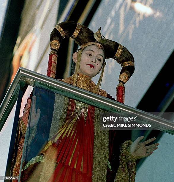 An unidentified girl, dressed as the character Queen Amidala from the new Star Wars film Episode 1 the Phantom Menace looks down 14 July 1999 from...