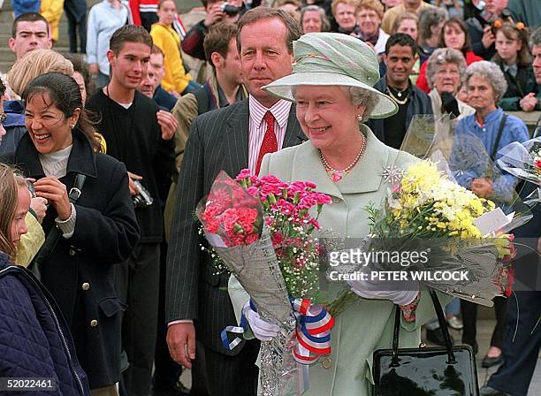 Britain's Queen Elizabeth smiles at crowds 22 July 1999 after leaving Liverpool Central Library during her visit to the city, where she is carrying...