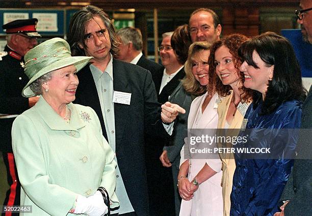 Britain's Queen Elizabeth, stops to chat to members of the cast from the TV soap 'Brookside' at Liverpool Central Library during her visit to the...