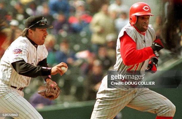 Colorado Rockies' Vinny Castilla runs down Dion Sanders of the Cincinnati Reds for an out in the first inning of their game 09 April at Coors Field...
