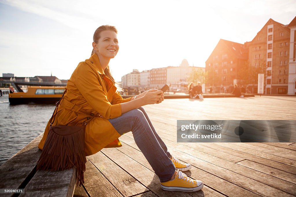 Woman in city enjoyng sun.